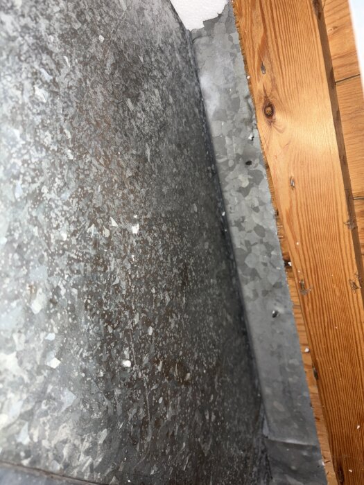 Ventilation genomföring i kallvind med fuktspår på golvet runt den, osäkert om det är läckage eller kondens.