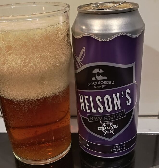 Burk och glas med öl "Nelson's Revenge" från Woodforde's Brewery, ett premium bitter ale, 4.5% alkohol.