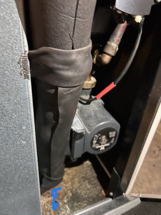 Närbild av en bergvärmepump med rostiga gängor och ny isolering som visar eventuell plats för köldbärarläckage.