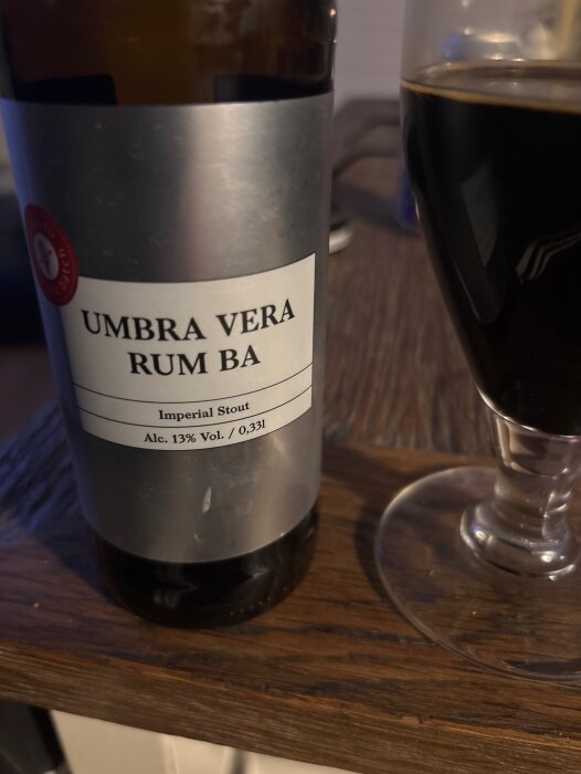 Flaska med Puhaste stout på romfat, etikett med "Umbra Vera", bredvid glas med mörk öl, alkoholhalt 13%.