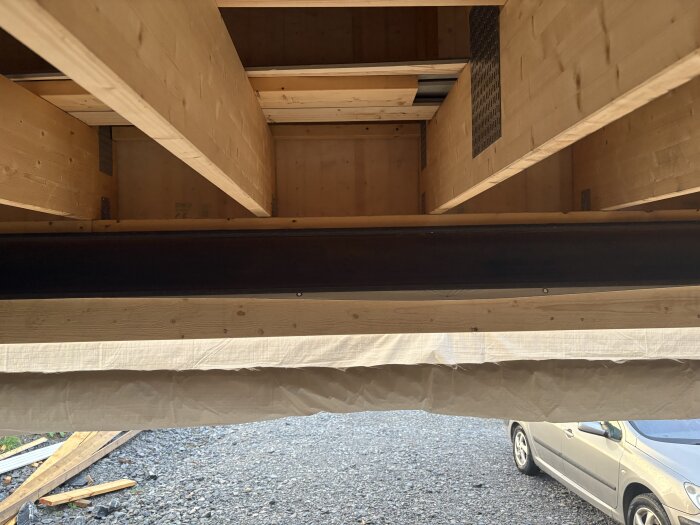 Stålbalk HEB220 över portöppning i garage, monterad mot reglar och plywood, diskussion kring köldbrygga och isoleringslösningar.