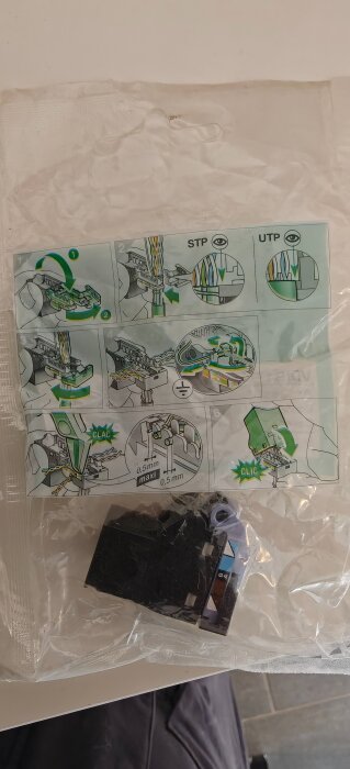 Plastpåse med monteringsanvisning för kabelanslutning och en svart komponent. Instruktioner visar korrekt kabeltrimming och insättning.