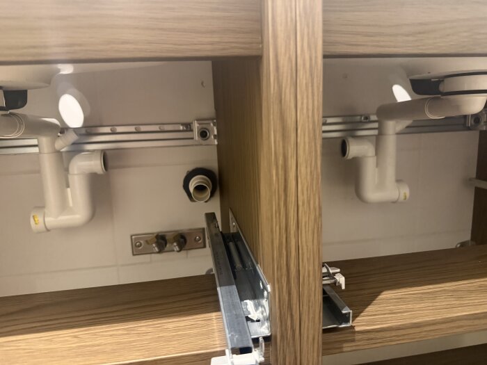 VVS-installation under diskbänk med IKEA T-koppling och röranslutningar ovanför trämöbel, behov av lösningsförslag.