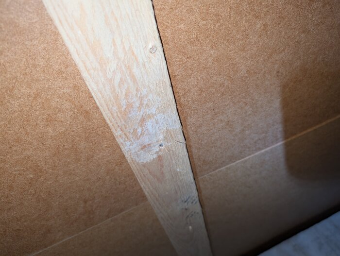 Träregel och fiberboard i närbild på en vägg under konstruktion eller renovering.