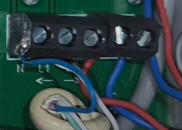 Nätadapteranslutning med flera färgglada kablar kopplade till ett kretskort. Terminaler märkta med "N" och "L1".