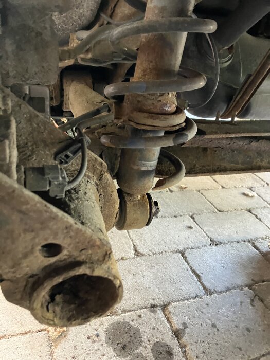 Fjäderben bytt bak på en Toyota Prius -07 med 24k mil, synligt på bild mot stenläggning.