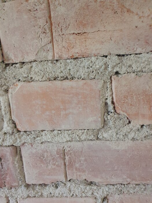 Närbild av en tegelvägg med cementfog, visar strukturen och murverket i detalj.