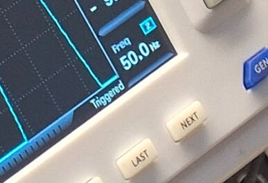 Skärm av en mätapparat som visar en frekvens på 50,0 Hz, troligen används för att mäta AC/AC adapter enligt inlägget.