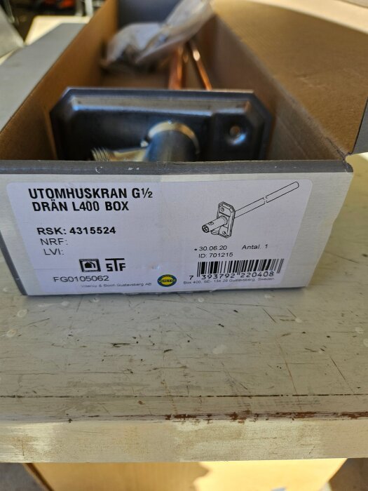Självdränerande utomhuskran G1/2, modell RSK 4315524, i förpackning på sliten träyta, med etikett och produktinformation.