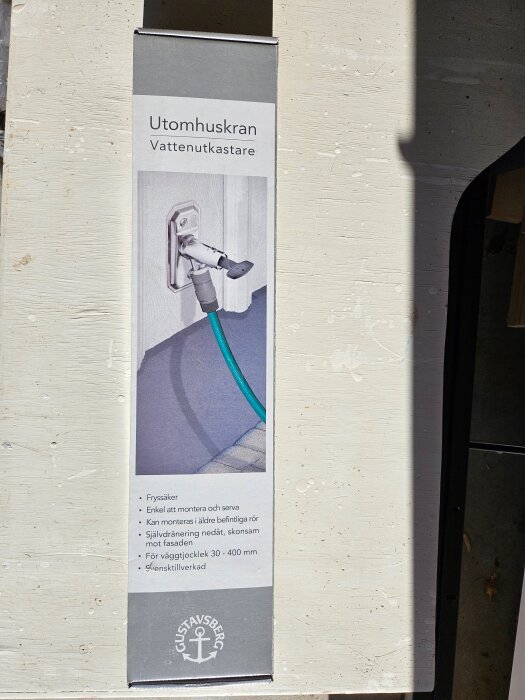 Förpackning av utomhuskran, vattenutkastare från Gustavsberg med text om monteringsfördelar, frostskydd och användning.