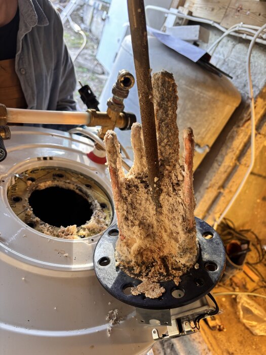 Kalkavlagringar på element från varmvattenberedare under reparation.