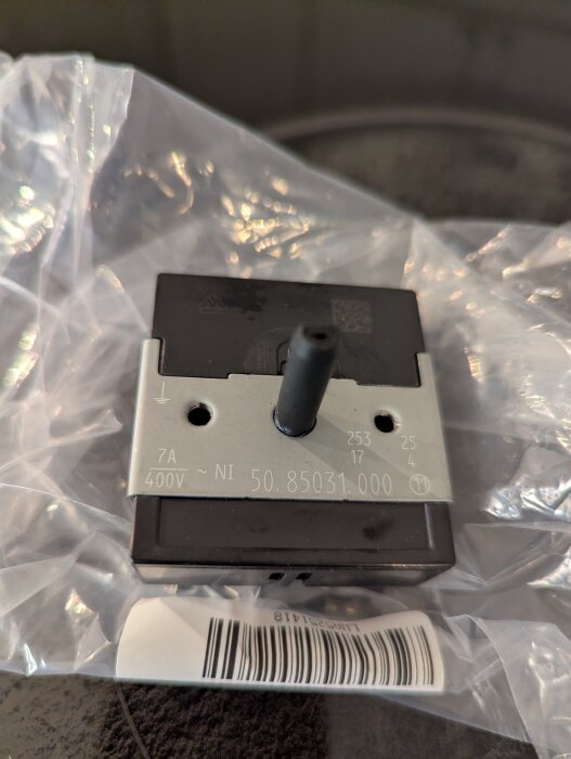 Energiregulator för spisens dubbelplatta med artikelnummer synligt, placerad på plastförpackning.