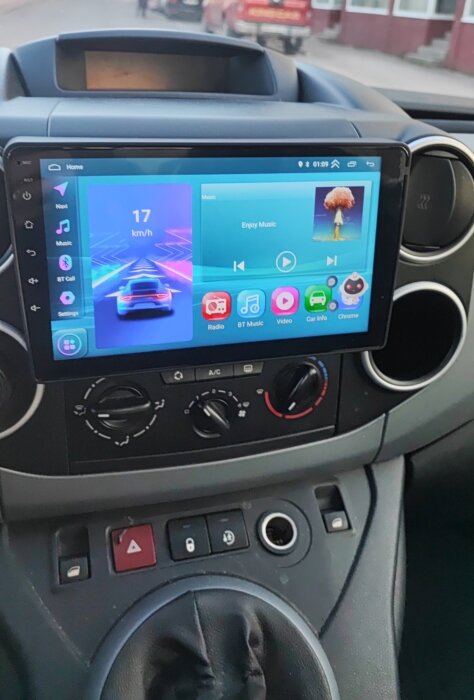 Bilens instrumentpanel med eftermarknadsstereo som visar hastighet och musikskärm, installerad i en Citroën Berlingo.
