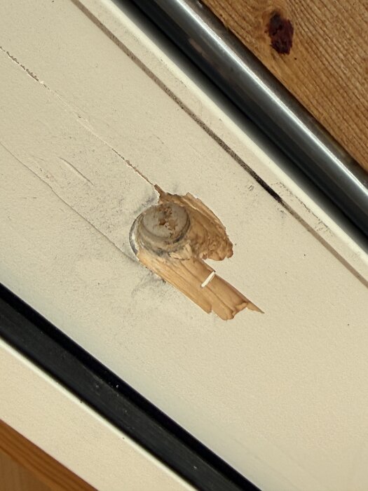 Skadad dörrkarm med trasigt trä och hål där en altandörr blåst upp.