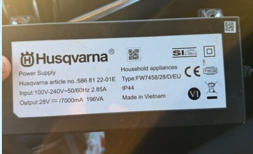 Strömförsörjning från Husqvarna med specifikationer som 28V och 7000mA visas.