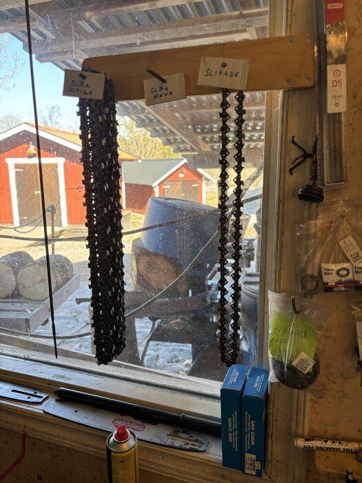 Kedjor från Biltema hänger under skyltar: "Slöa Skitiga", "Slöa Rena" och "Slipade", i en verkstad med redskap i bakgrunden.