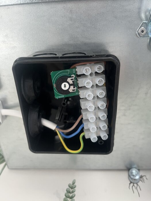 Svart låda med lock under fläkt, visande en krets och flera kablar, frågan gäller om detta justerar fläktens kraft.