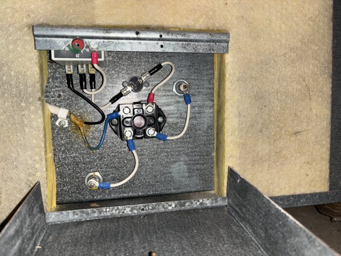 Elektrisk kopplingsbox med kablar och anslutningar i ett RDAA-aggregat på vinden. Temp-givare hänger löst utan kabelanslutning.
