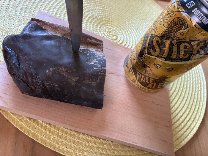 Torkat älgkött på träskärbräda med en kniv och en burk Sticks Pale Ale bredvid.