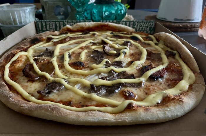 Pizza med oxfilé, fläskfilé, sparris och bearnaisesås i kartong.
