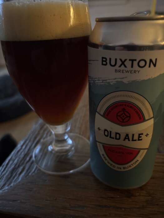 En öl från Buxton Brewery, märkt "Old Ale", bredvid ett glas fyllt med mörk ale och skummande topp.