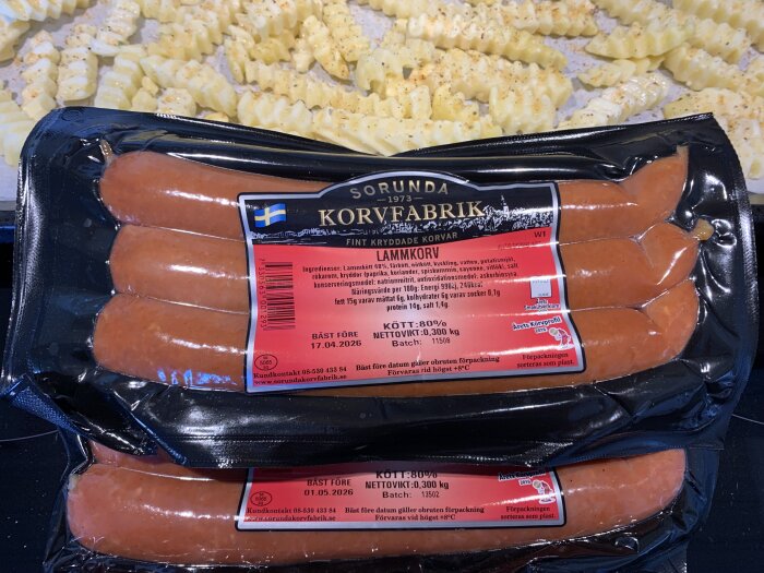 Paket med lammkorv från Sorunda Kött & Korv och skivad pommes frites på bakplåt.