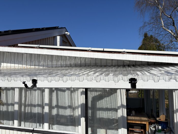 Plasttak monterat över en veranda med kort överlapp på hängrännan och planerat överhäng för cirkelsågning vid behov.