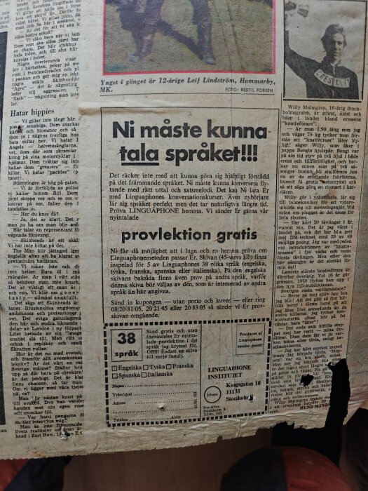 Gammal tidning från 1969 med annonser och artiklar, använd som byggmaterial i en innervägg. Tidningen har gulnat med tiden och är något trasig.