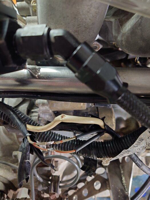 Korroderad koppartråd och skadad kabel i motorutrymme, visar trolig orsak till laddningsproblem.