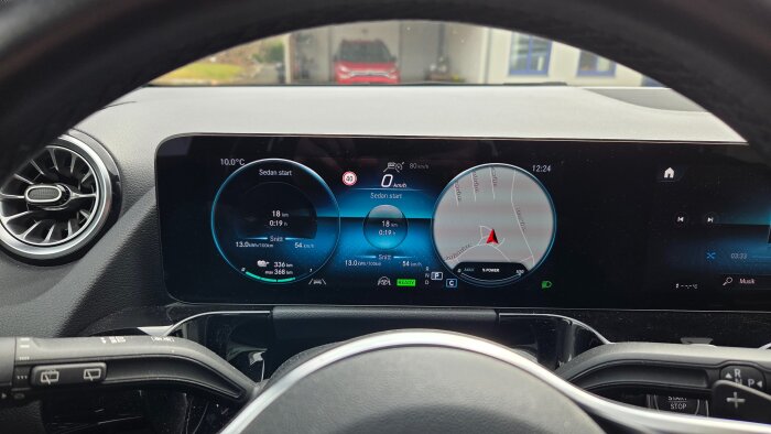 Bilens instrumentbräda visar 18 km kört avstånd, 13 kWh/100km energiförbrukning, och aktuell hastighet. GPS-karta syns också.