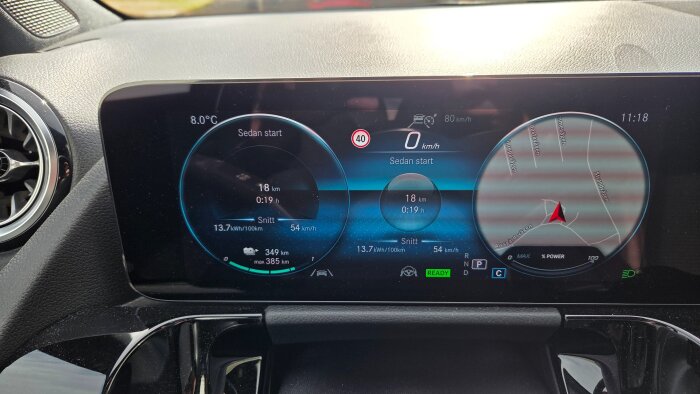 Instrumentpanel som visar bilens körsträcka, hastighet och energiförbrukning på 13,7 kWh/100 km samt navigationskartläget med vägnamn.