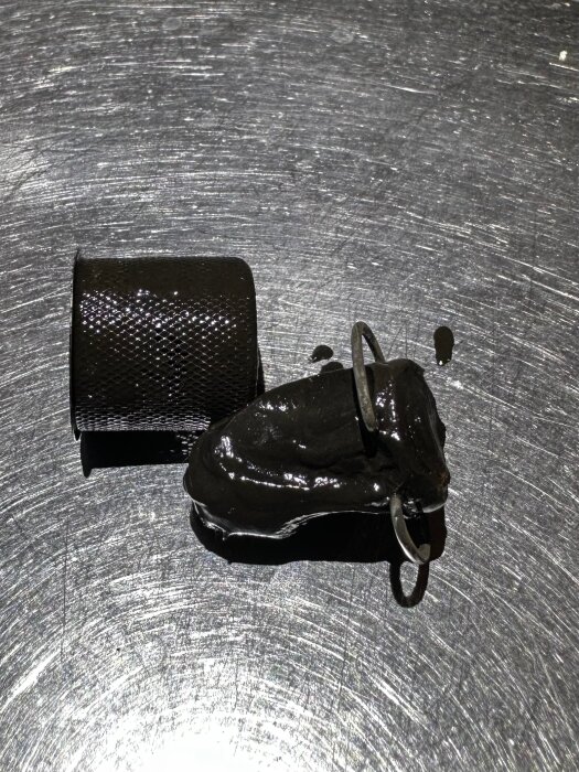 Filterbollen av magnetmaterial täckt av svart magnetit, placerad på en metallisk yta, visar upp ansamlad magnetit under fyra timmar.