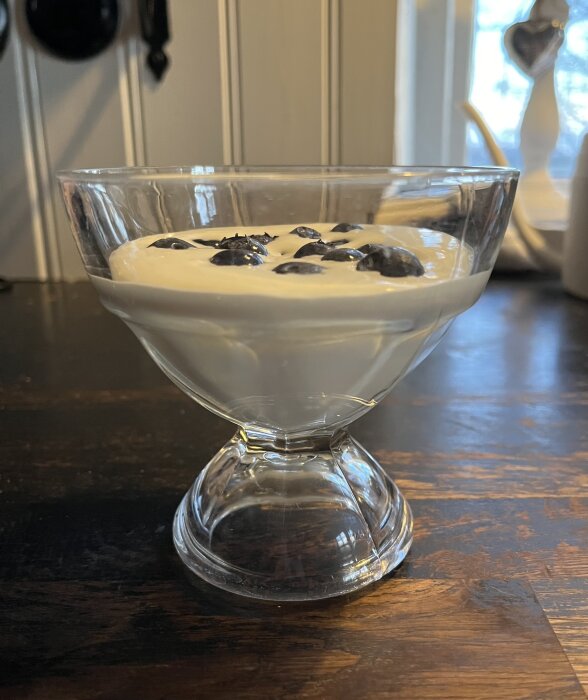 Mascarponekräm toppad med blåbär i ett glas, serverat som dessert.