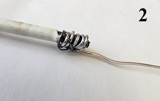 En metalltråd virad runt en annan tråd vid en stavs ände, del av reparation med ståltråd och epoxy, nummer 2 ovanför.