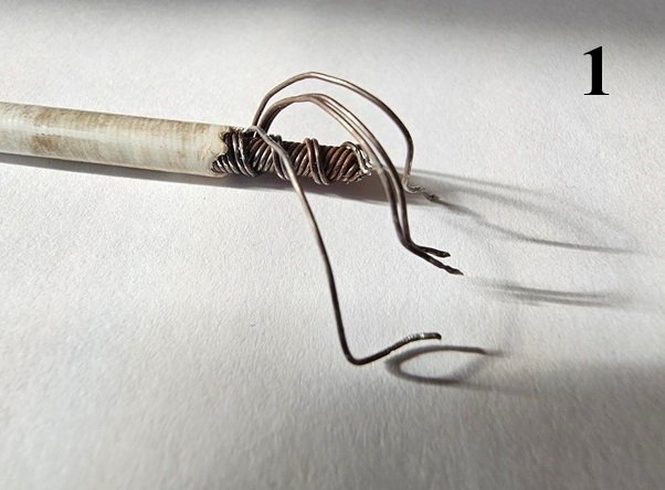 Närbild på en vajer med avskalad plast som har trådar flätade ihop med ståltråd, och två plastpluggar fästa med epoxy.