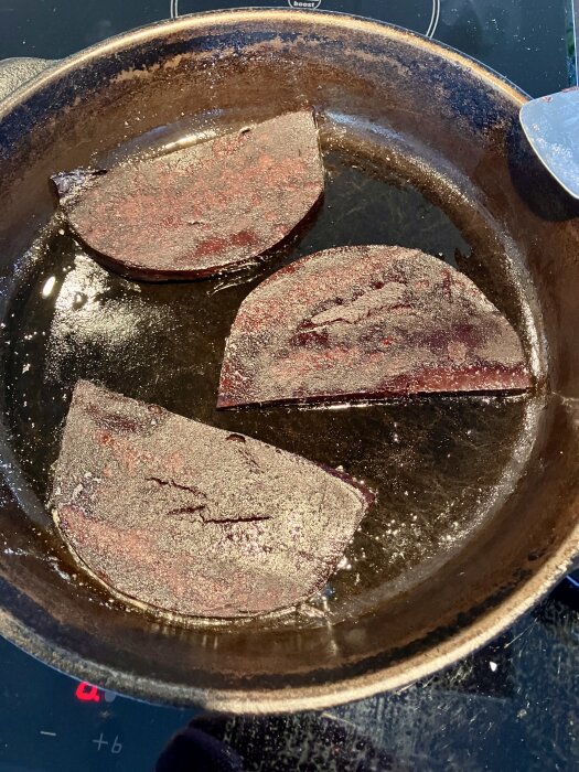 Stekta skivor blodpudding i en stekpanna.