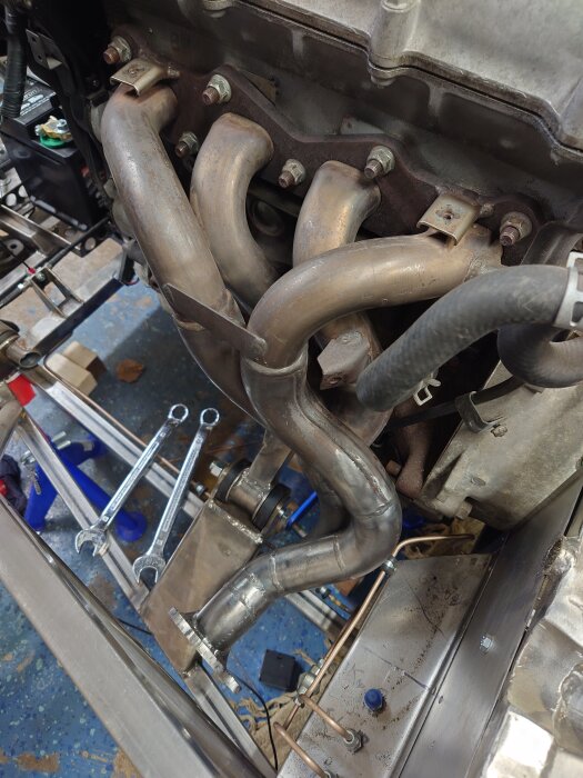 Motor med installerat avgassystem och verktyg.