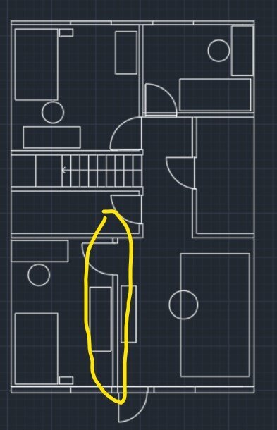 Planritning av ett hus med markerad sektion för planerad vägg vid trappa, visande rum och dörrar.