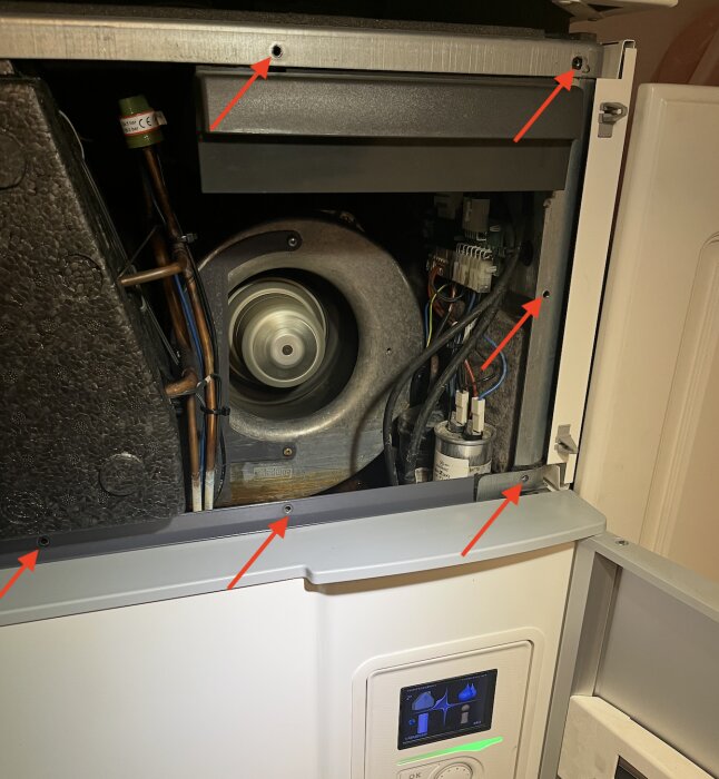 Inuti en öppen FVP-enhet med exponerad fläkt och komponenter, markerade skruvar och elektriska anslutningar, vid underhåll eller reparation.