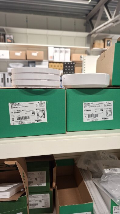 Kartonger med Schneider Electric dosor och påväggskapslar, i hylla på lager.