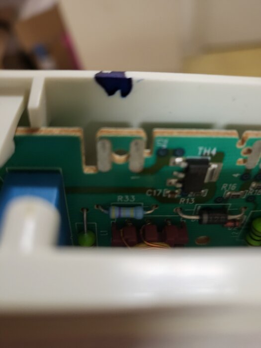 Kretskort med komponenter som en resistor märkt "R33" och en transistor, möjlig felsökning för frysvens fläkt.
