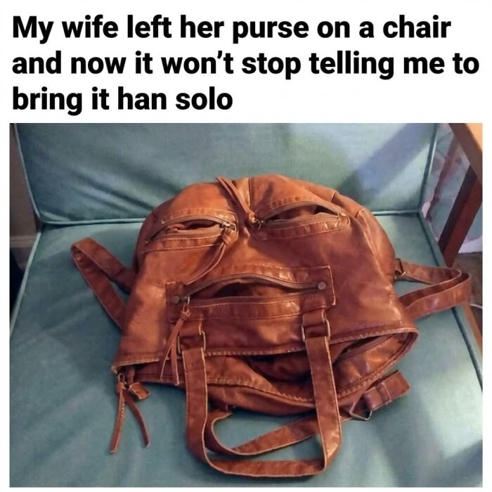 En brun väska med remmar och fickor, placerad på en stol, som ser ut som ett ansikte. Text ovanför säger att den påminner om en Star Wars-karaktär.