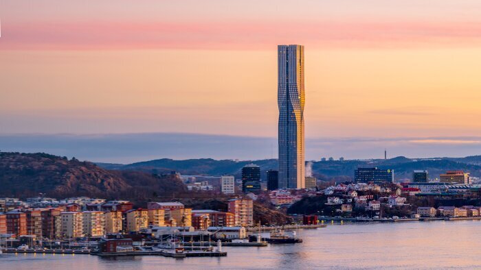 Vy över Karlatornet i Göteborg i solnedgången, omgiven av vatten och stadsmiljö.