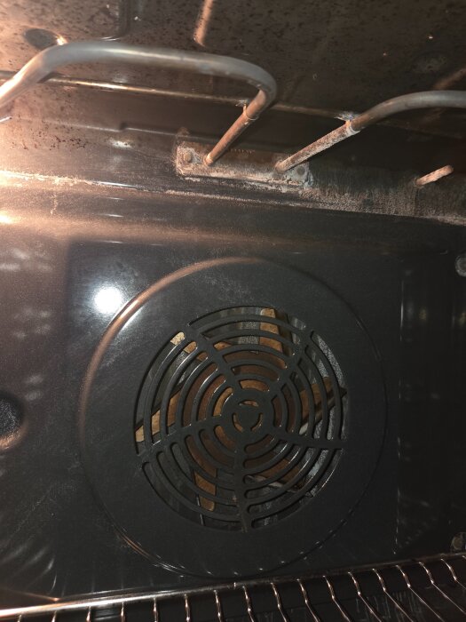 Ugnselement som hänger ner från taket i en ugn, frågor kring om det bör fästas upp för säkerhet.