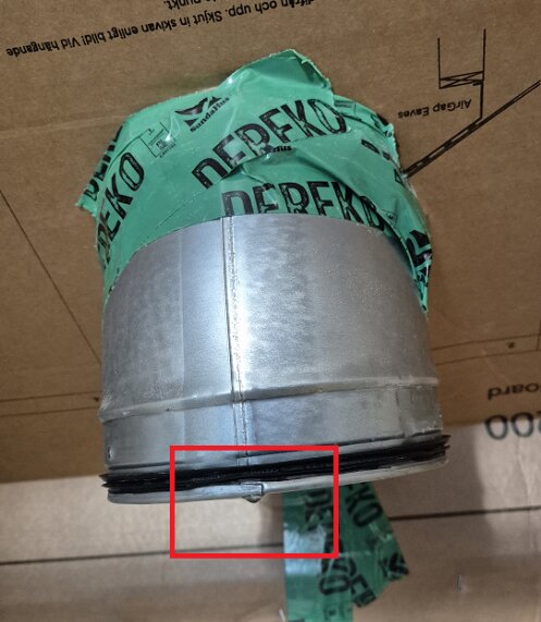 Isolerad svart takhuv med förpackningsmaterial påvisat stående ovanpå kartong, lekkage misstänks orsaka vattendropp genom spirorör.