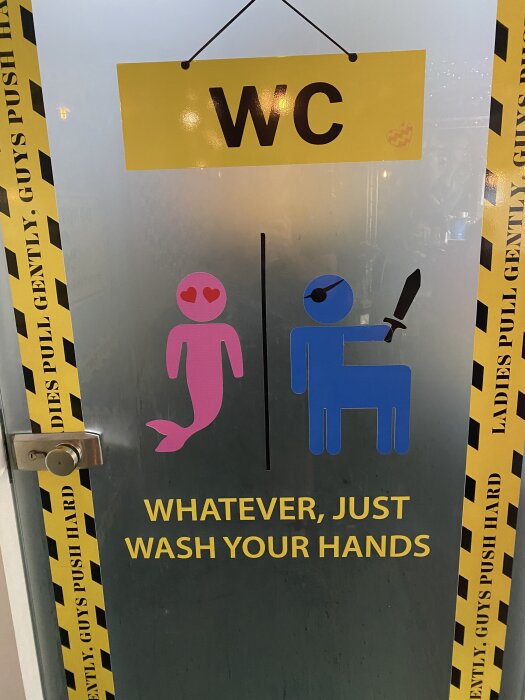 Toalett dörr med symboler av en rosa sjöjungfru och en blå pirat, med texten "WHATEVER, JUST WASH YOUR HANDS".