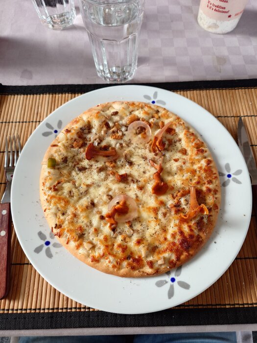 Pizza toppad med picklade kantareller på en tallrik.