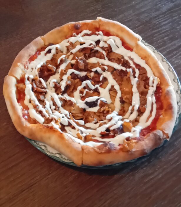 Kebabpizza med vitlökssås serverad på ett bord.
