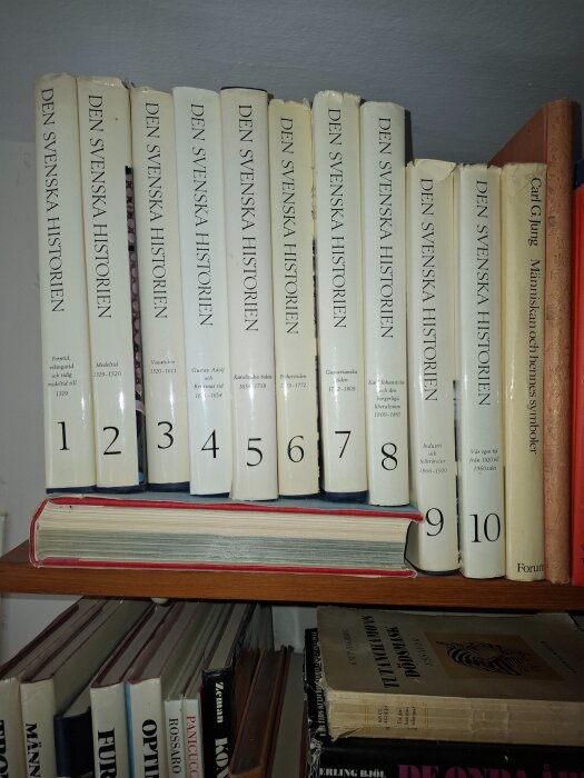 Bokhylla med tio volymer av "Den svenska historien", numrerade 1 till 10, fokuserade på olika historiska perioder i Sverige.