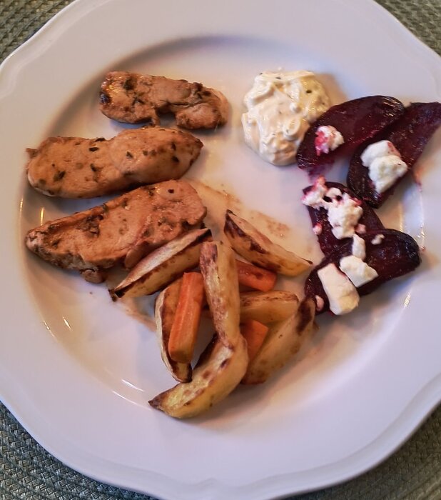 Stekt kycklingbröstfilé med cajunkrydda, ugnsrostad potatis och morötter, rödbetor med fetaost och en klick bearnaisesås på tallrik.